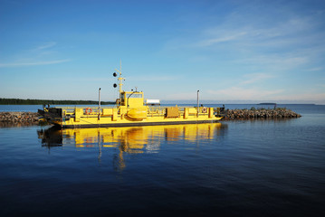 Yellow ferry in the blue water of Manamansalo