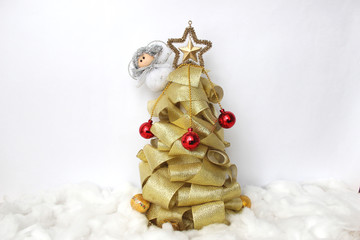 Christmas angel is hiding behind the beautiful unusual tree