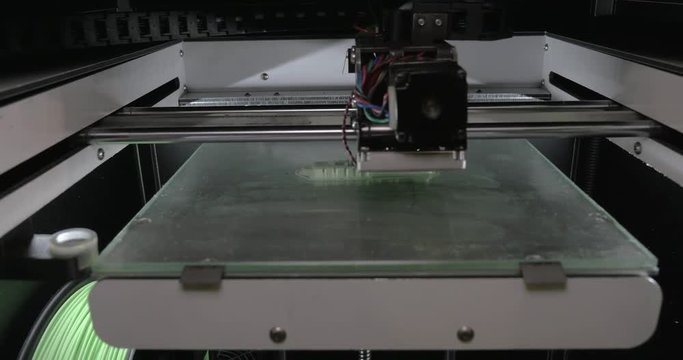 Close-up view of mechanism of 3d printer making white plastic object