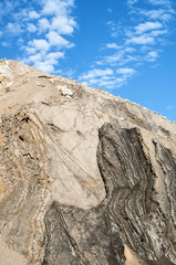 Slope of  abandoned stone quarry on blue sky background in sunny day
