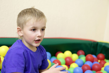 Boy playing in box of balls