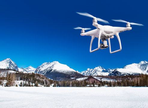 Hovering drone taking pictures of white winter nature