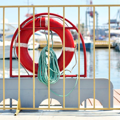Red life buoy on a background of navy pier.