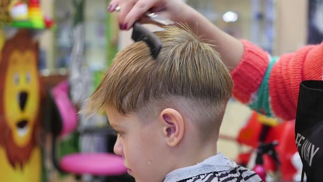 haircut of a child with scissors in the barbershop