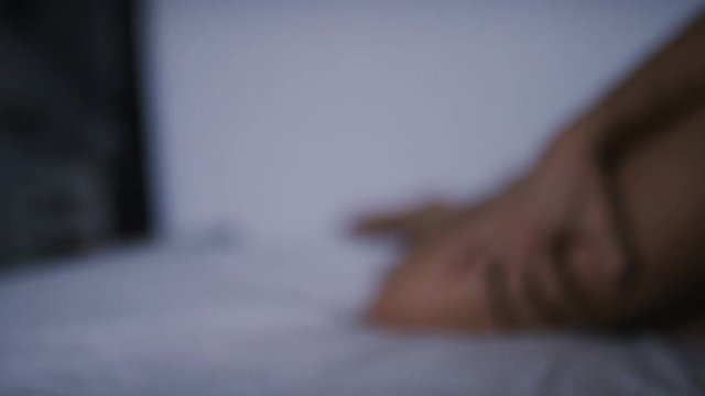 4K Female hand reaches out during passion on a bed as two lovers hold hands, in slow motion