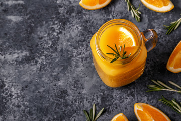 Fresh ripe oranges and juice on stone table.