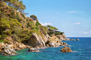 Obraz premium Beautiful natural rock near of Tossa de Mar, Costa Brava, Spain. Bay and crystal clear water of Mediterranean Sea. Amazing blue green sea and sunny day.