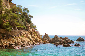 Naklejka premium Beautiful natural rock near of Tossa de Mar, Costa Brava, Spain. Bay and crystal clear water of Mediterranean Sea. Amazing blue green sea and sunny day.