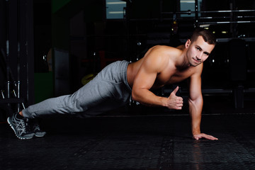 Naklejka premium man doing push-up at gym .