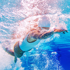 Swimmer underwater. Female swimmer with tattoos