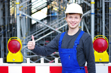 junger Mann in Arbeitskleidung auf der Baustelle