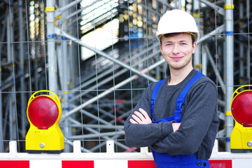 junger Mann in Arbeitskleidung auf der Baustelle