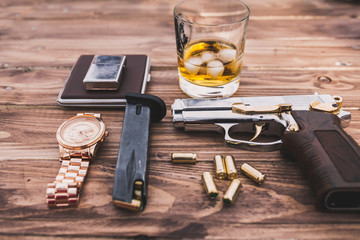 Obraz na płótnie Canvas whiskey, watches, silver pistol on the table