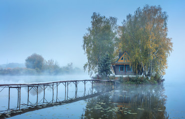 Obraz premium blue foggy morning with embankment to fishing house