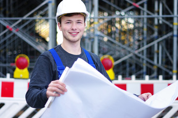 junger Mann in Arbeitskleidung auf der Baustelle