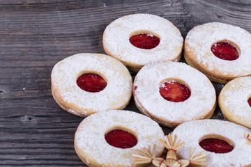 Homemade Christmas sweets with sugar powder and jam on old woode