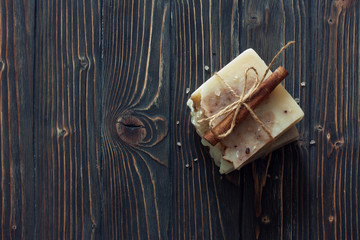 Bars of handmade soap over dark wood background. Top view.