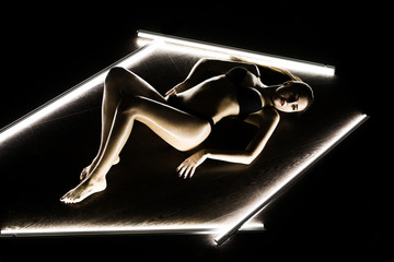 sexy girl in the Studio. Body in oil. The light from the lamp