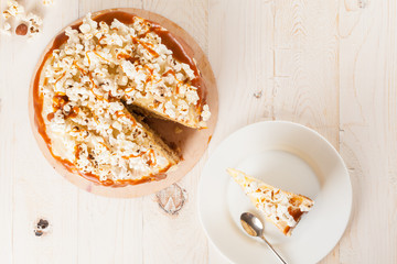 Homemade cake with hazelnuts and salty caramel with vanilla - hazel shortcakes and delicate hazelnut cream, decorated with salty popcorn. Top view.
