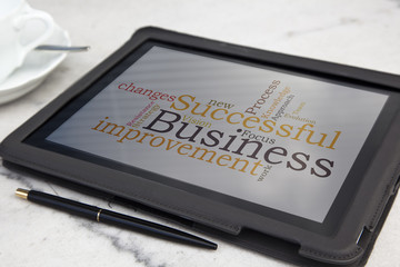 tablet with successful business word cloud