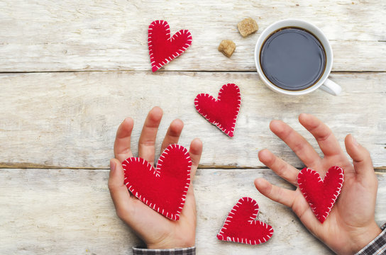 Men's hands hold toy hearts for Valentine's Day