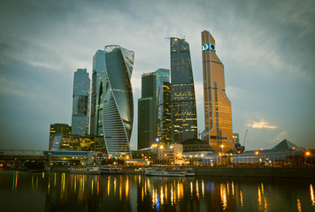 Plakat skyscrapers on banks of the river in the evening