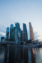 Fototapeta na wymiar skyscrapers on banks of river in the evening