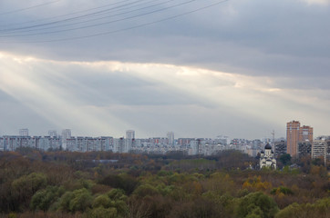 Obraz premium Sun rays in clouds above the town