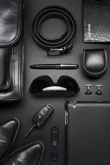 Man accessories in business style, briefcase, gadgets, shoes, clothes and other luxury businessman attributes on leather black background, fashion industry, top view  - 127747121