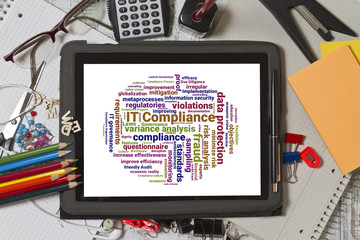 Tablet screen with IT compliance word cloud shaped as a circle