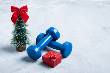Christmas sport composition with dumbbells, red gift box, christ