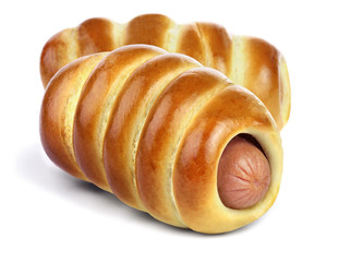 The sausage in the ruddy yeast bun with a golden crust isolated on white background.