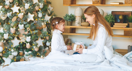 Fototapeta na wymiar happy family mother and child daughter on Christmas morning tre