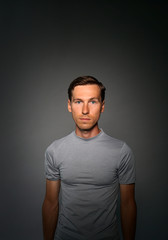 Young man in t-shirt on gray background.