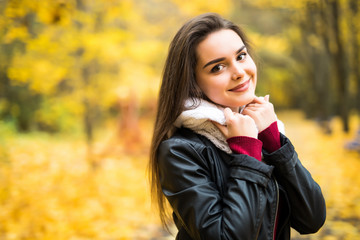 Fototapeta na wymiar Beautiful elegant woman standing in a park in autumn