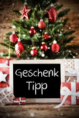 Fototapeta na wymiar Christmas Tree With Bokeh Effect, Geschenk Tipp Means Gift Tip