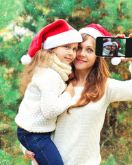 Fototapeta premium Christmas smiling mother and child taking picture self portrait