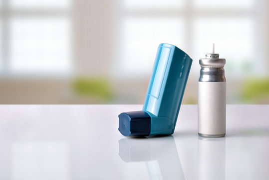 Cartridge and blue medicine inhaler in a room front view