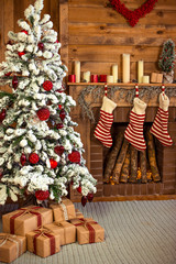 Beautiful holiday decorated home room with Christmas tree, gifts under it and red Christmas socks.