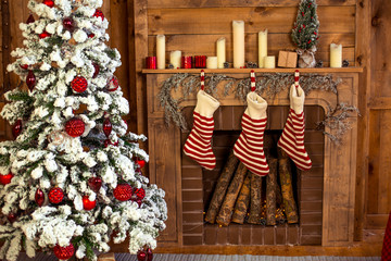 Beautiful holiday decorated home room with Christmas tree, gifts under it and red Christmas socks.