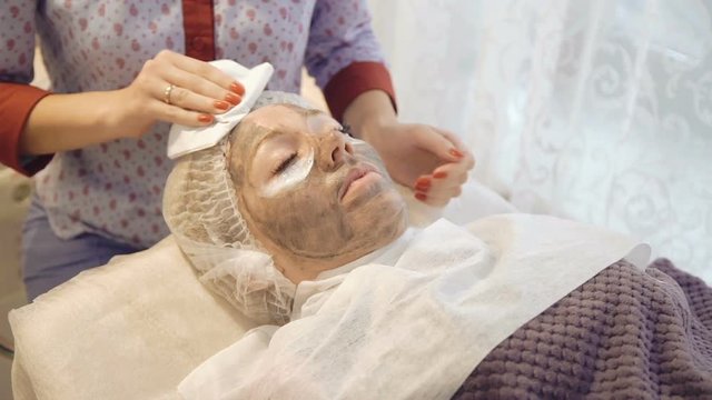 Taking off marine mug mask from female face