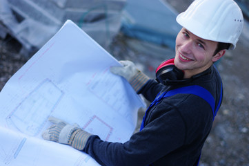 Mann mit Plänen auf der Baustelle, Planung 