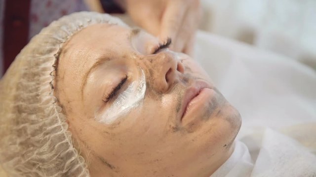 Taking off marine mug mask from female face