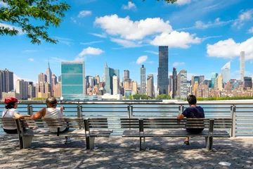 Fotobehang NewYorkers at a park in Queens with a view of the midtown Manhattan skyline © kmiragaya