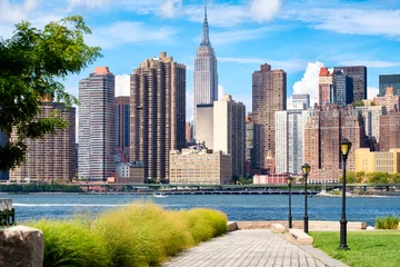  De skyline van Midtown Manhattan in New York City op een mooie zomerdag gezien vanuit een park in Queens © kmiragaya