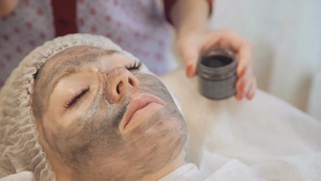 Applying marine mug mask on female face