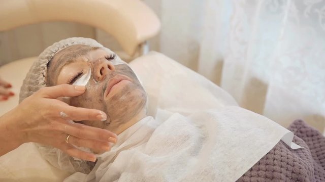 Applying marine mug mask on female face