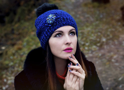 Portrait of a woman in a knitted hat, looking to the sky