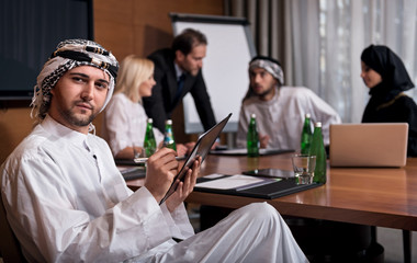 Handsome bearded Arab man working in the group