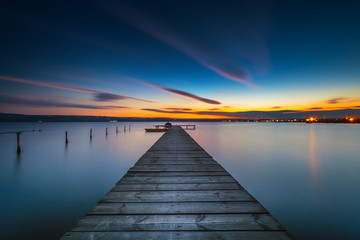 Naklejka na ściany i meble Wooden Dock and fishing boat at the lake, sunset shot